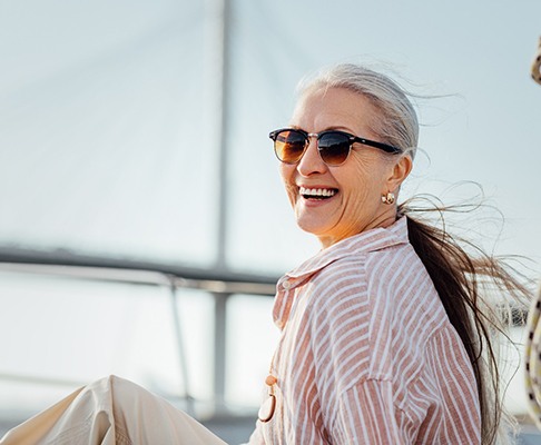 a woman smiling and sitting on a sailboat 