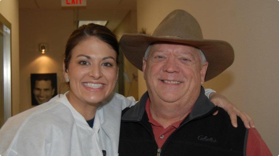 Dental team member and patient smiling together at event