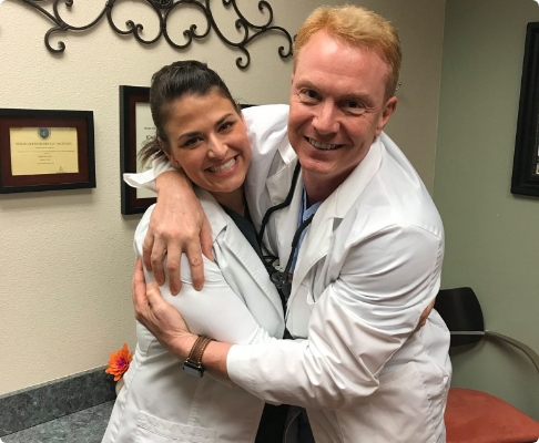 Doctor Huckabee hugging another dentist