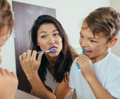 Mother and child brushign teeth to prevent dental emergencies