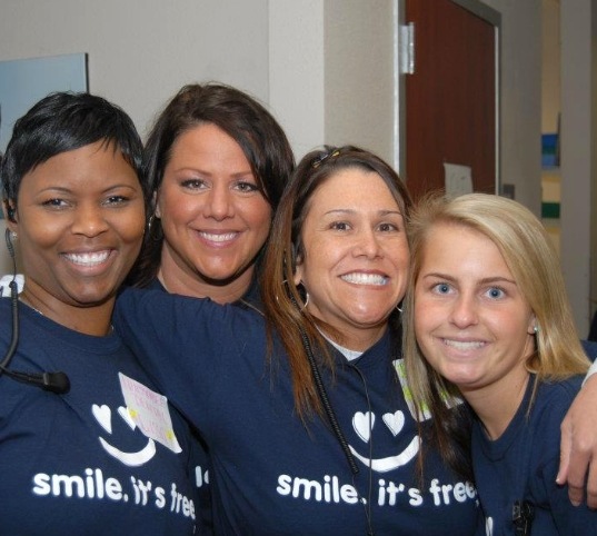 Four smiling dental team members