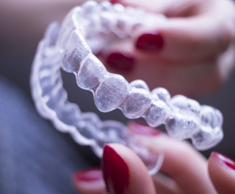 Dental patient holding an Invisalign tray