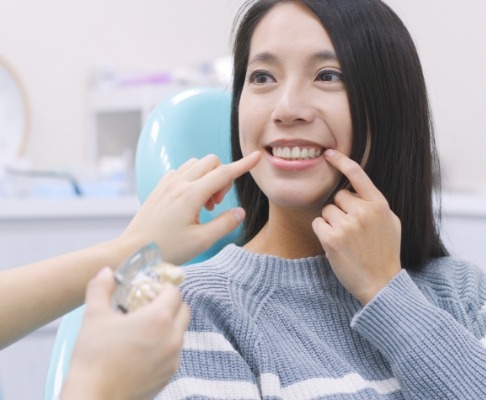 Woman pointing to smile before tooth extraction