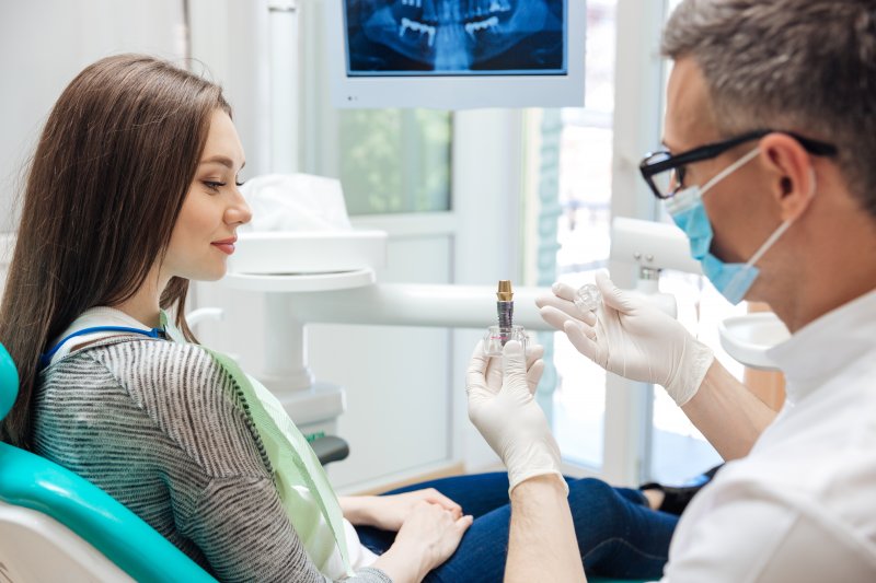 woman learning about dental implants from dentist