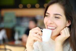Woman smiling over a small espresso