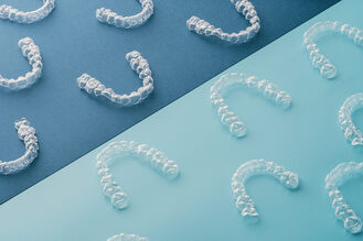 Multiple Invisalign aligners arranged neatly, representing orthodontic treatment at Huckabee Dental.
